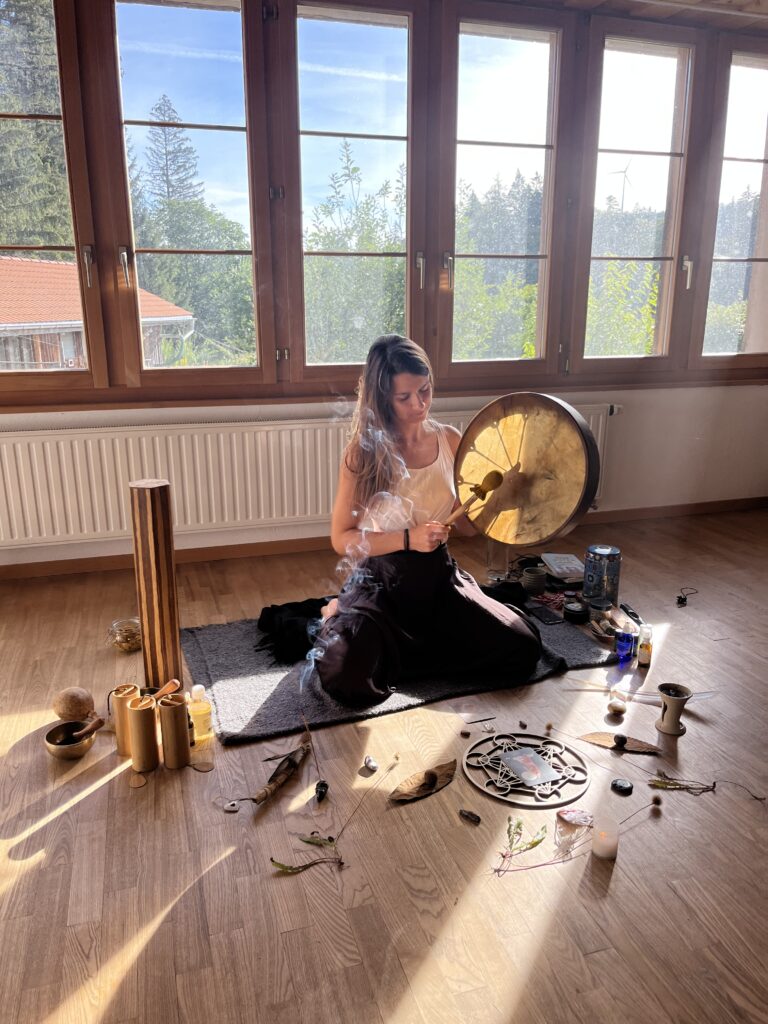 Femme assise avec un tambour dans un espace cérémoniel
