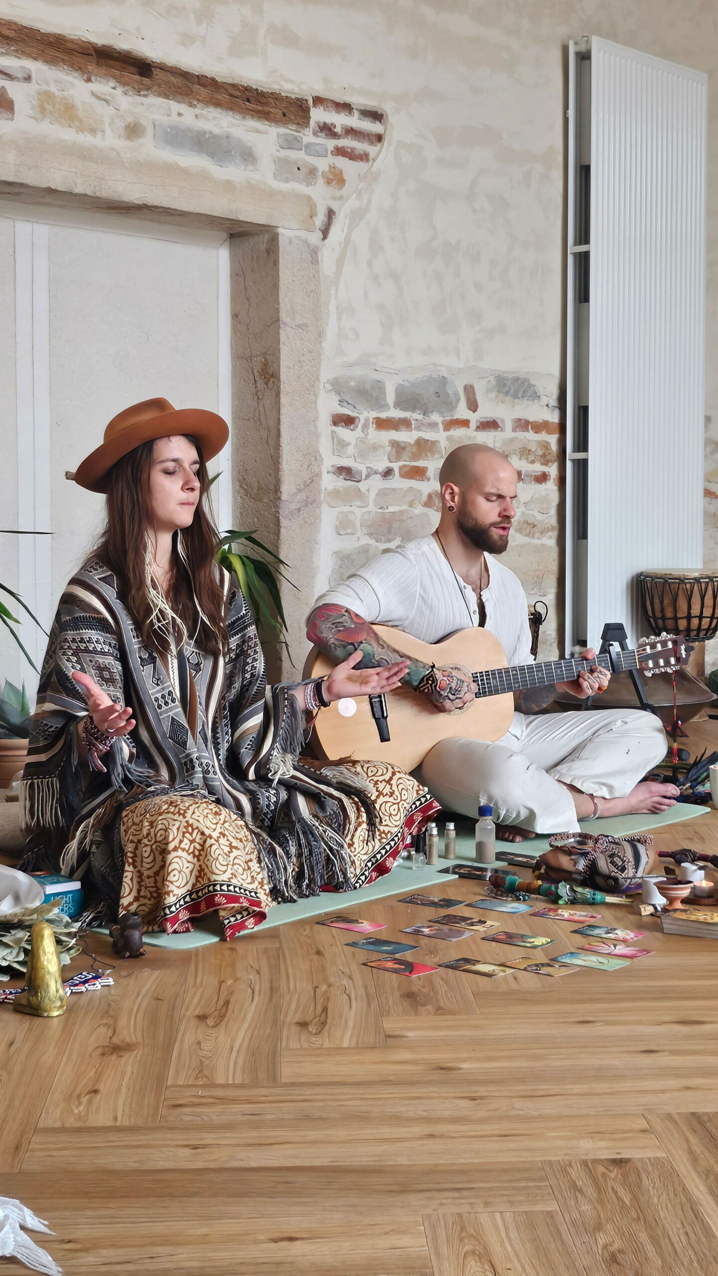 Femme en poncho chantant, accompagnée d'un homme à la guitare
