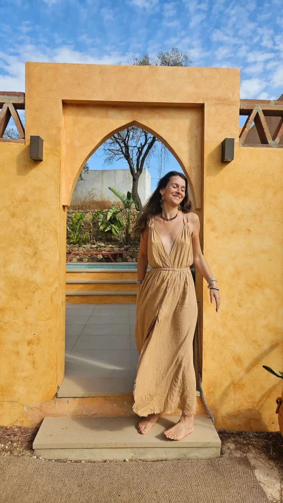 Femme debout dans une porte en arche ocre